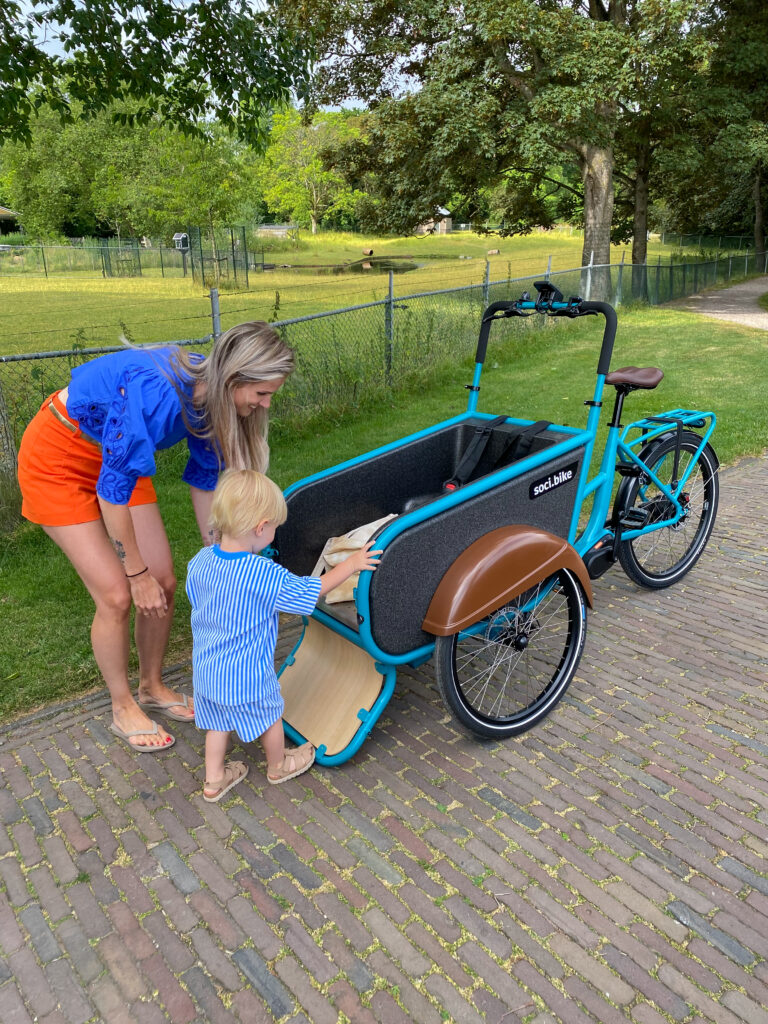 SociBike Compact blauw klep open en kindje die instapt