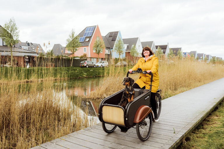 SociBike Compact met vrouw in gele jas en hond in de bak